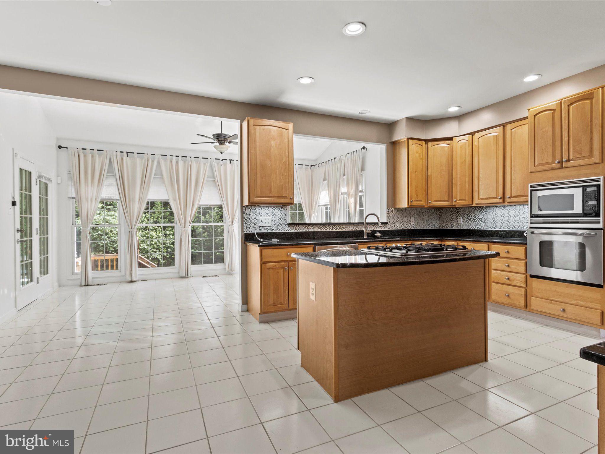 1505 Ridge Forest Way Hanover, MD 21076 - Photo 10 of 40 a kitchen with stainless steel appliances granite countertop a stove a sink and a refrigerator