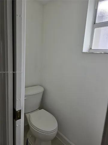 a white toilet sitting next to a white cabinet