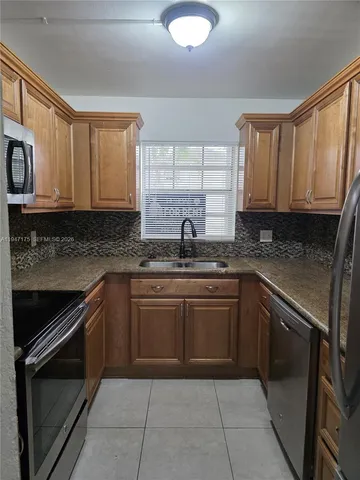 a kitchen with a sink stove and cabinets