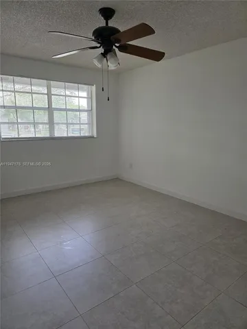 an empty room with a empty space and a ceiling fan