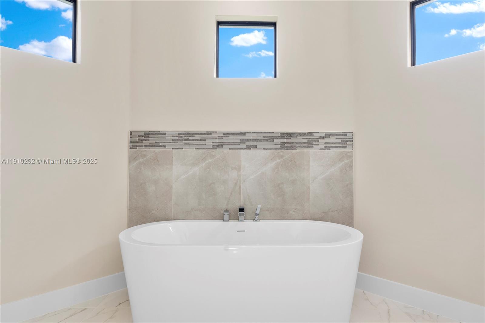 4100 8th Street Southwest Lehigh Acres, FL 33976 - Photo 20 of 24 a white bath tub sitting in a bathroom