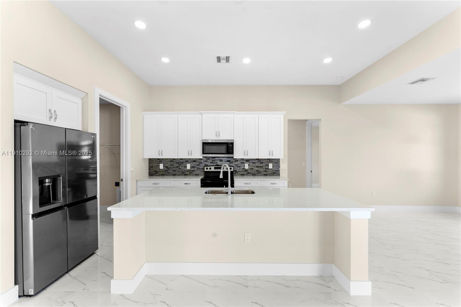 4100 8th Street Southwest Lehigh Acres, FL 33976 - Photo 7 of 24 a kitchen with stainless steel appliances a refrigerator and a stove top oven