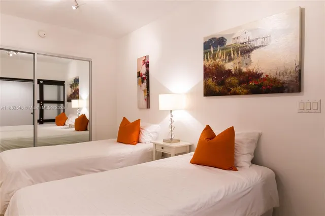 a bedroom with a bed and painting on the wall