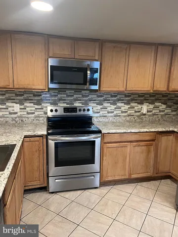 a kitchen with stainless steel appliances granite countertop a sink stove and microwave