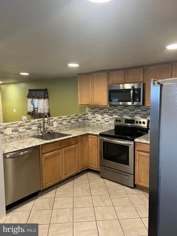 a stove top oven sitting inside of a kitchen