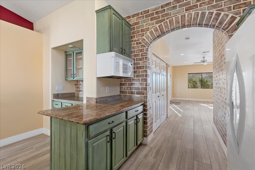 120 Ringlore Road Henderson, NV 89015 - Photo 17 of 58 A striking brick archway frames the entry to this open kitchen featuring stone countertops.