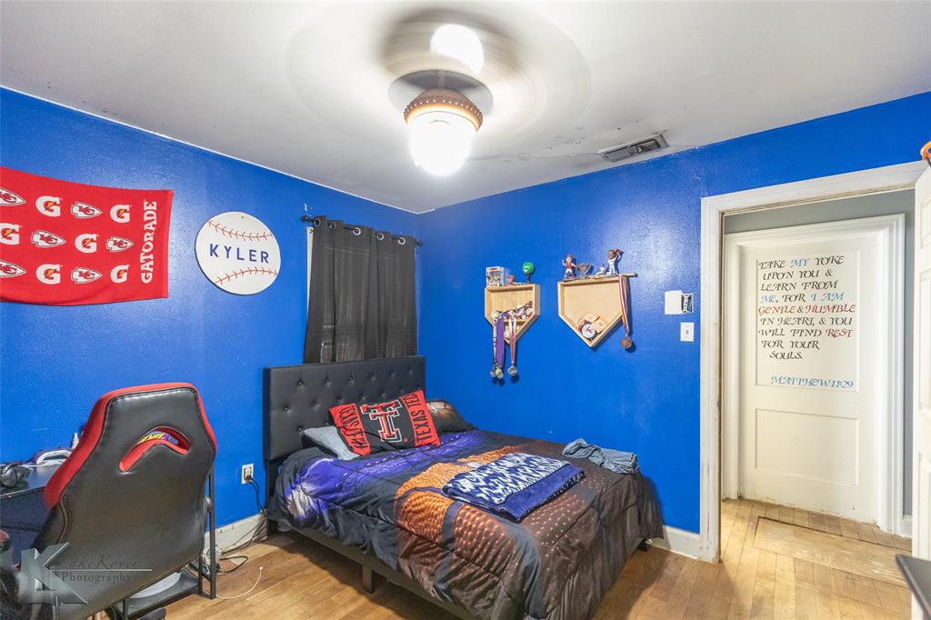 1649 South 16th Street Abilene, TX 79602 - Photo 20 of 24 a bedroom with a bed and a chandelier