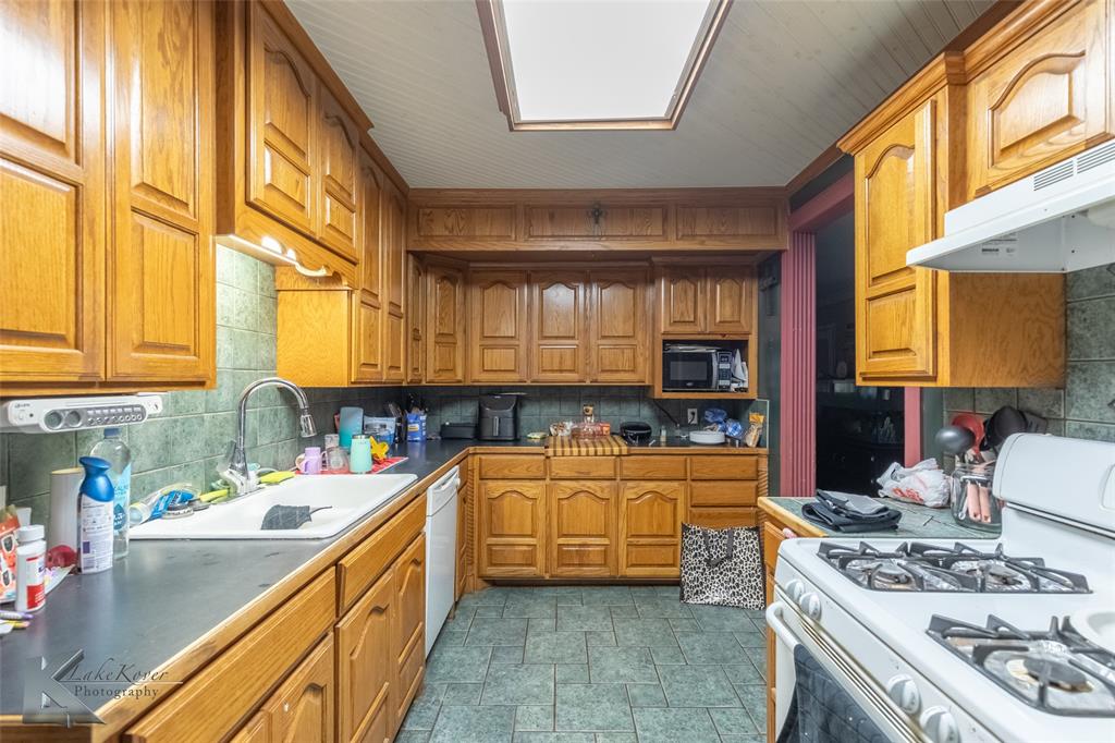 1649 South 16th Street Abilene, TX 79602 - Photo 7 of 24 a kitchen with stainless steel appliances granite countertop a sink a stove and a wooden cabinets