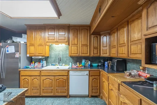 a kitchen with stainless steel appliances granite countertop a sink a stove and cabinets