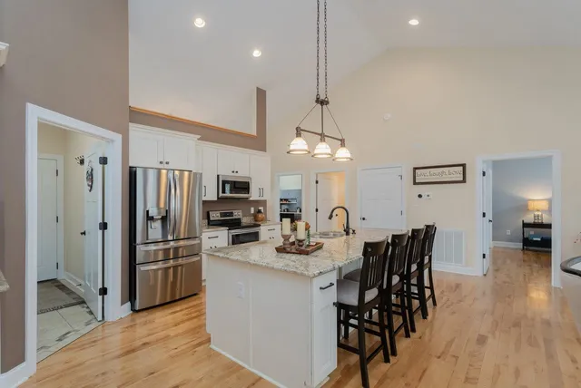 a kitchen with stainless steel appliances granite countertop a sink stove microwave and refrigerator
