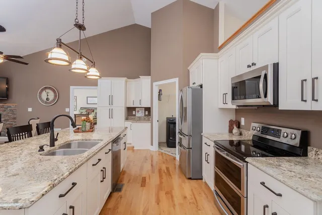 a kitchen with stainless steel appliances granite countertop a stove refrigerator and cabinets