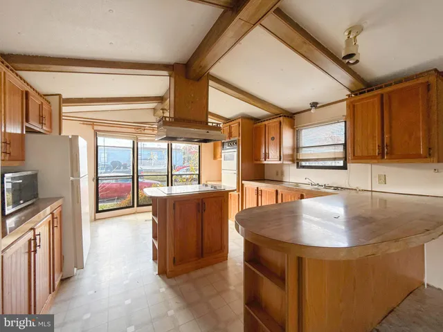 a kitchen with stainless steel appliances granite countertop a sink a stove and a refrigerator