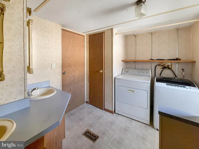 a room with a sink a chair and a refrigerator