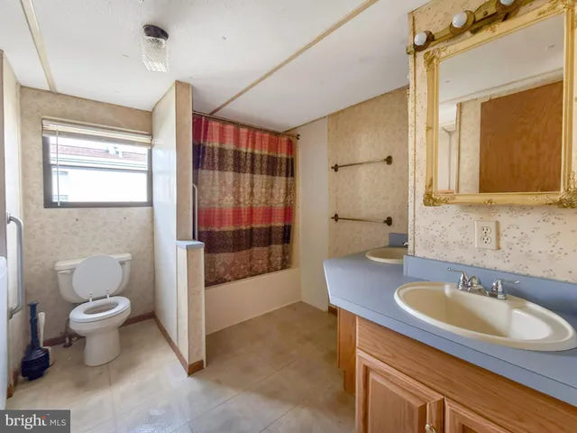 a bathroom with a sink toilet a mirror and shower