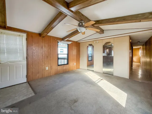a view of a hallway with wooden floor and a living room