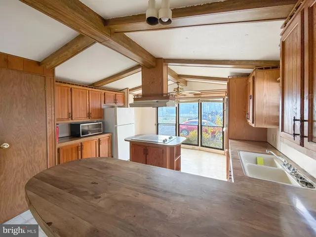 a large kitchen with stainless steel appliances granite countertop a large oven a sink and a refrigerator