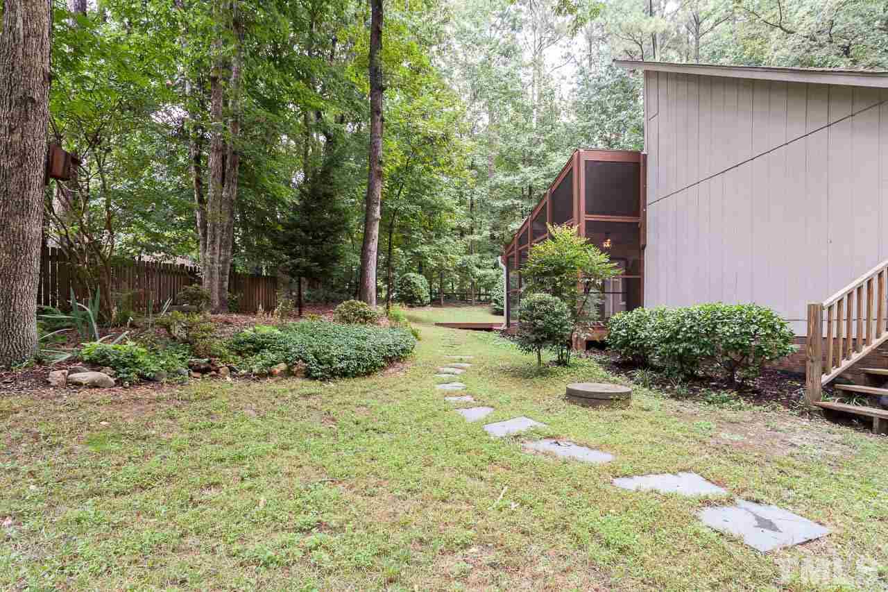 8008 Chadbourne Court Raleigh, NC 27613 - Photo 22 of 25 a backyard of a house with a garden and plants