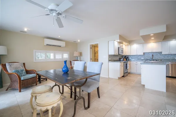 a kitchen with stainless steel appliances kitchen island granite countertop a table chairs and a refrigerator