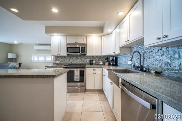 a kitchen with stainless steel appliances granite countertop a sink stove and cabinets
