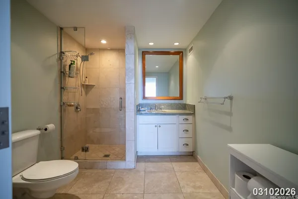 a bathroom with a granite countertop sink a toilet and shower