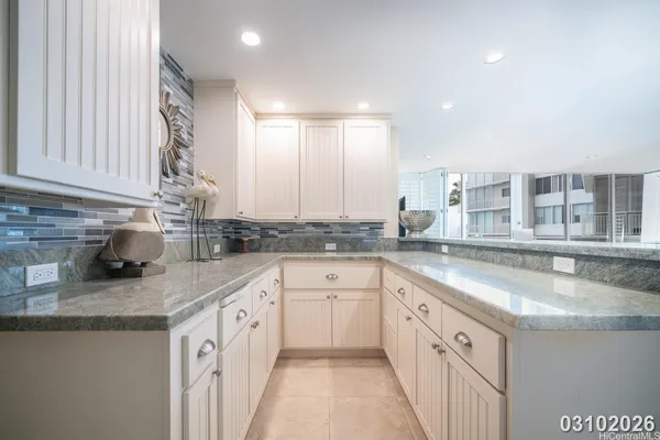 a kitchen with granite countertop a sink stove and cabinets