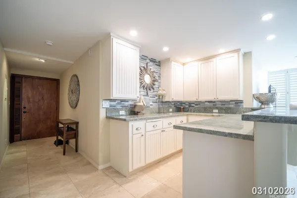 a kitchen with granite countertop a sink a stove cabinets and a dining table