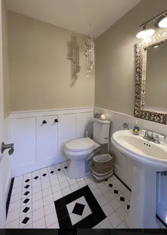 a bathroom with a sink toilet and mirror