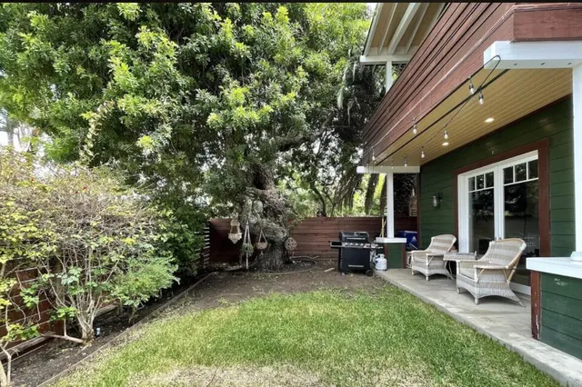 a view of a house with backyard sitting area and garden