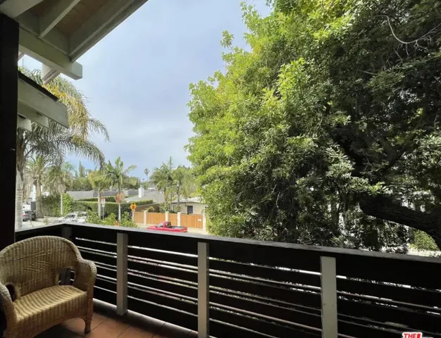 a view of balcony with wooden floor and fence