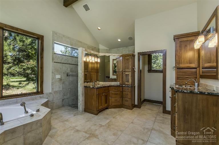 64245 Schibel Road Bend, OR 97703 - Photo 11 of 18 a bathroom with a tub a sink a mirror and a shower