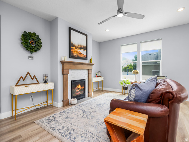 877 South Yarrow Drive Mapleton, UT 84664 - Photo 3 of 46 Living area featuring a gas fireplace with a wood mantle and hexagonal tile surround, light wood-finish flooring, two large windows, recessed lighting, and a ceiling fan
