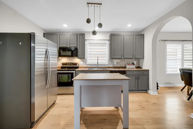 a kitchen with a refrigerator and a stove top oven
