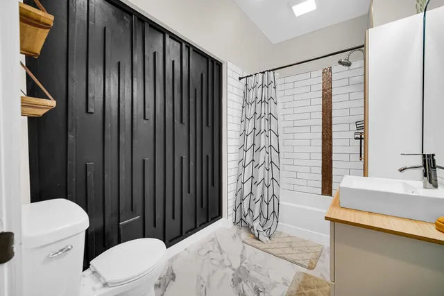 a bathroom with a toilet a sink and a shower curtain