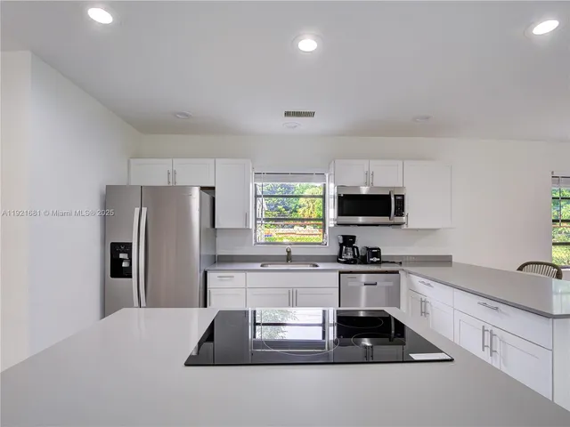 a kitchen with granite countertop a refrigerator and a sink
