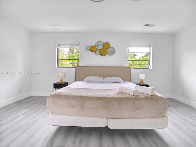 a bedroom with a bed and painting on the wall
