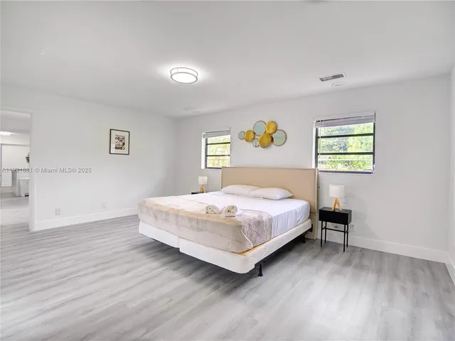 a bedroom with a bed and painting on the wall