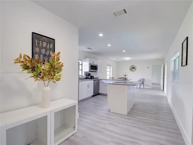 a kitchen with a refrigerator and a potted plant
