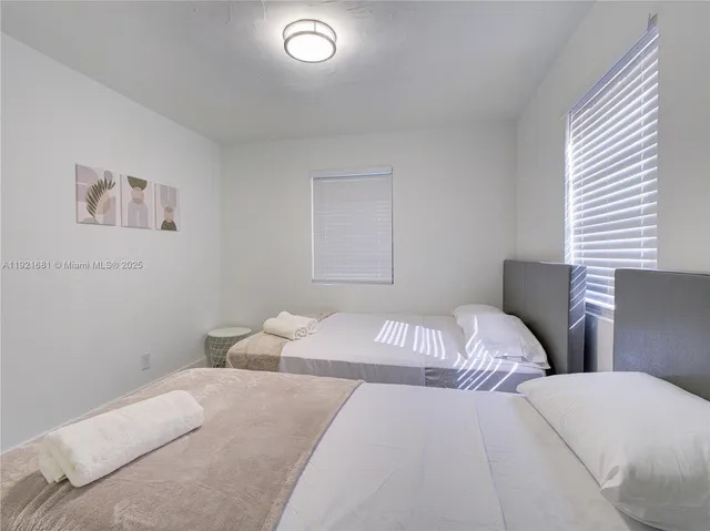 a bedroom with two beds and a lamp