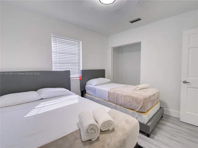 a bedroom with two beds and a window