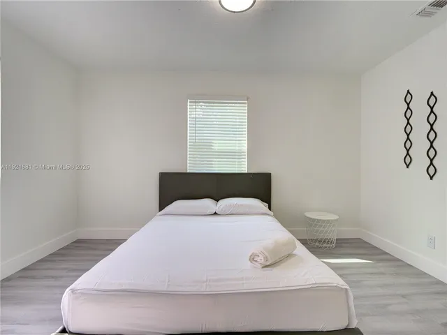 a bedroom with a bed and a night stand
