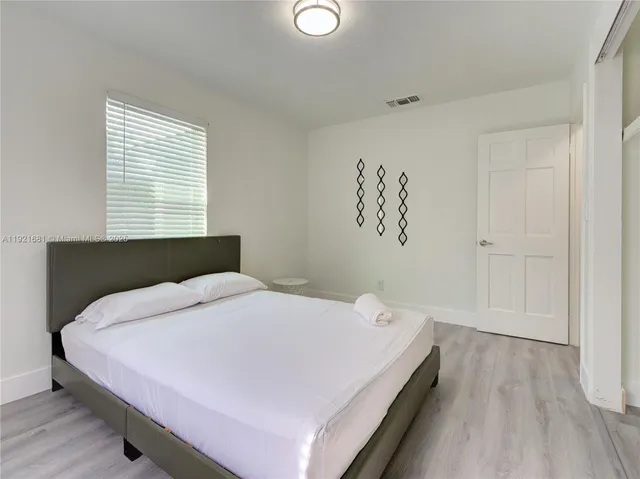 a bed sitting in a bedroom next to a window