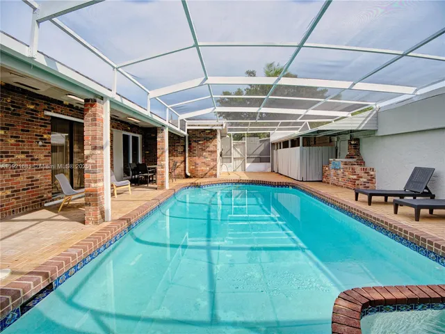 a view of a backyard with a patio and a wooden fence