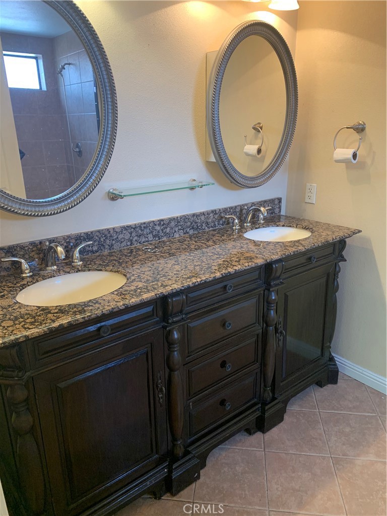 5246 Calderon Road Woodland Hills, CA 91364 - Photo 12 of 50 a bathroom with a granite countertop double vanity sink and a mirror