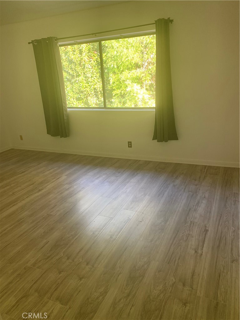 5246 Calderon Road Woodland Hills, CA 91364 - Photo 43 of 50 a view of an empty room with wooden floor and a window