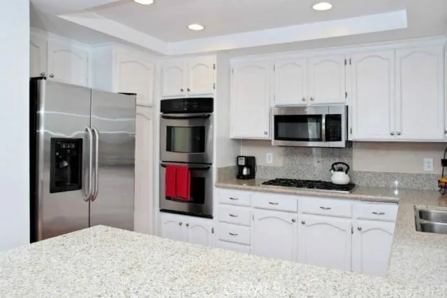 a kitchen with stainless steel appliances granite countertop a refrigerator and a microwave