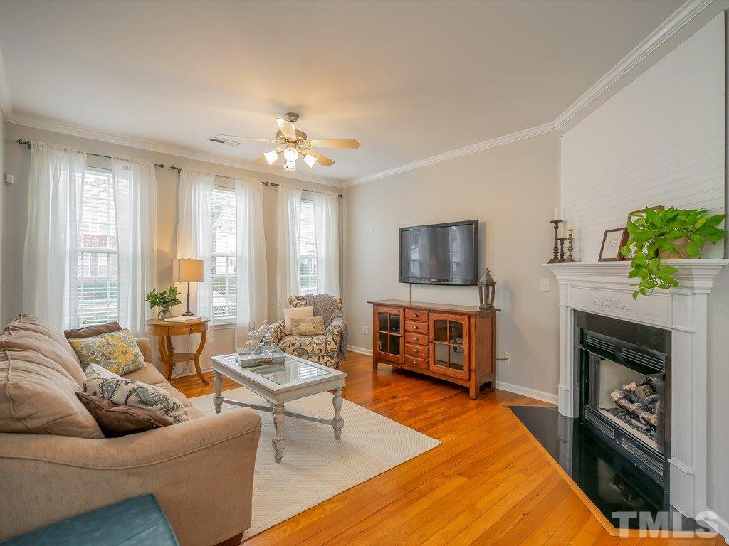 7865 Spungold Street Raleigh, NC 27617 - Photo 2 of 15 a living room with furniture a flat screen tv and a fireplace