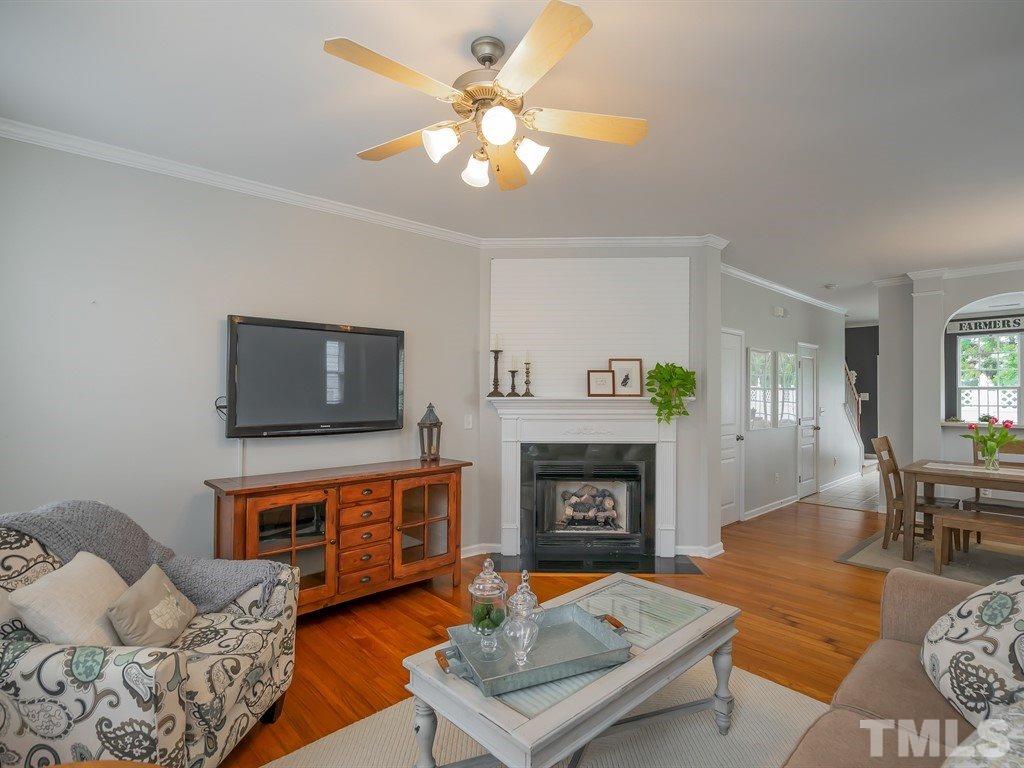 7865 Spungold Street Raleigh, NC 27617 - Photo 4 of 15 a living room with furniture a flat screen tv and a fireplace