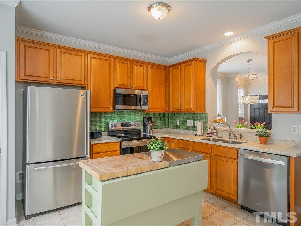 7865 Spungold Street Raleigh, NC 27617 - Photo 7 of 15 a kitchen with stainless steel appliances a refrigerator sink and cabinets