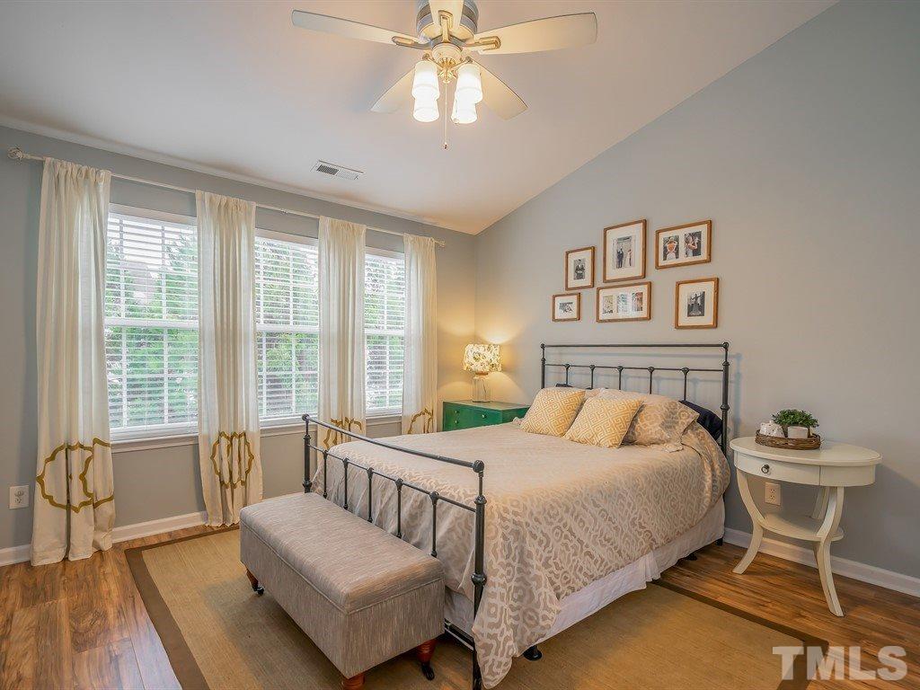 7865 Spungold Street Raleigh, NC 27617 - Photo 8 of 15 a bedroom with a bed and a chandelier