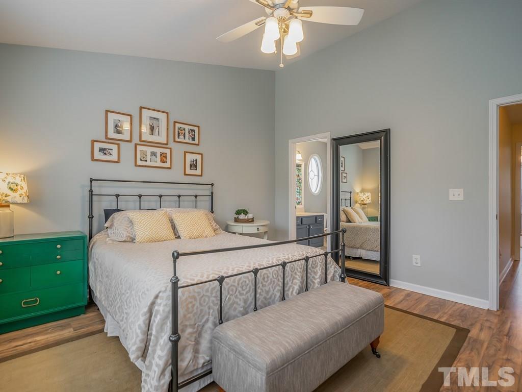 7865 Spungold Street Raleigh, NC 27617 - Photo 9 of 15 a bedroom with a large bed and a chandelier